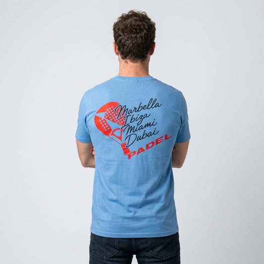 A man viewed from behind wearing a light blue t-shirt with a red and black graphic print on the back. The graphic features a design made of a padel racket and the text 'Marbella, Ibiza, Miami, Dubai' and 'PADEL'.
